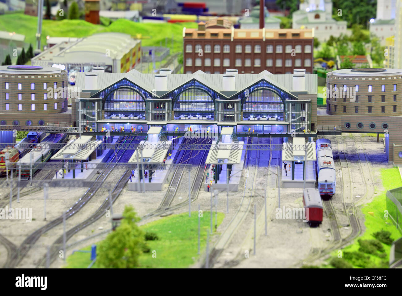 model of railroad station. railroad, trains, trees, grass, humans and buildings. focus on building in center of image. Stock Photo