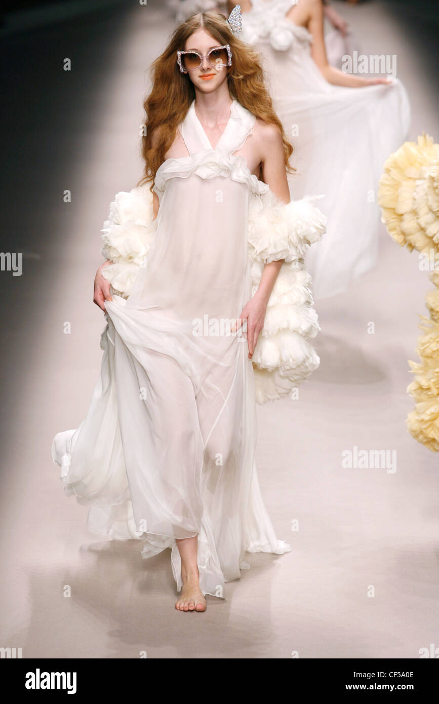 Strappy transparent white floor length diaphanous nightgown, accessorized ruffled feather chubbies and tinted oversize Stock Photo