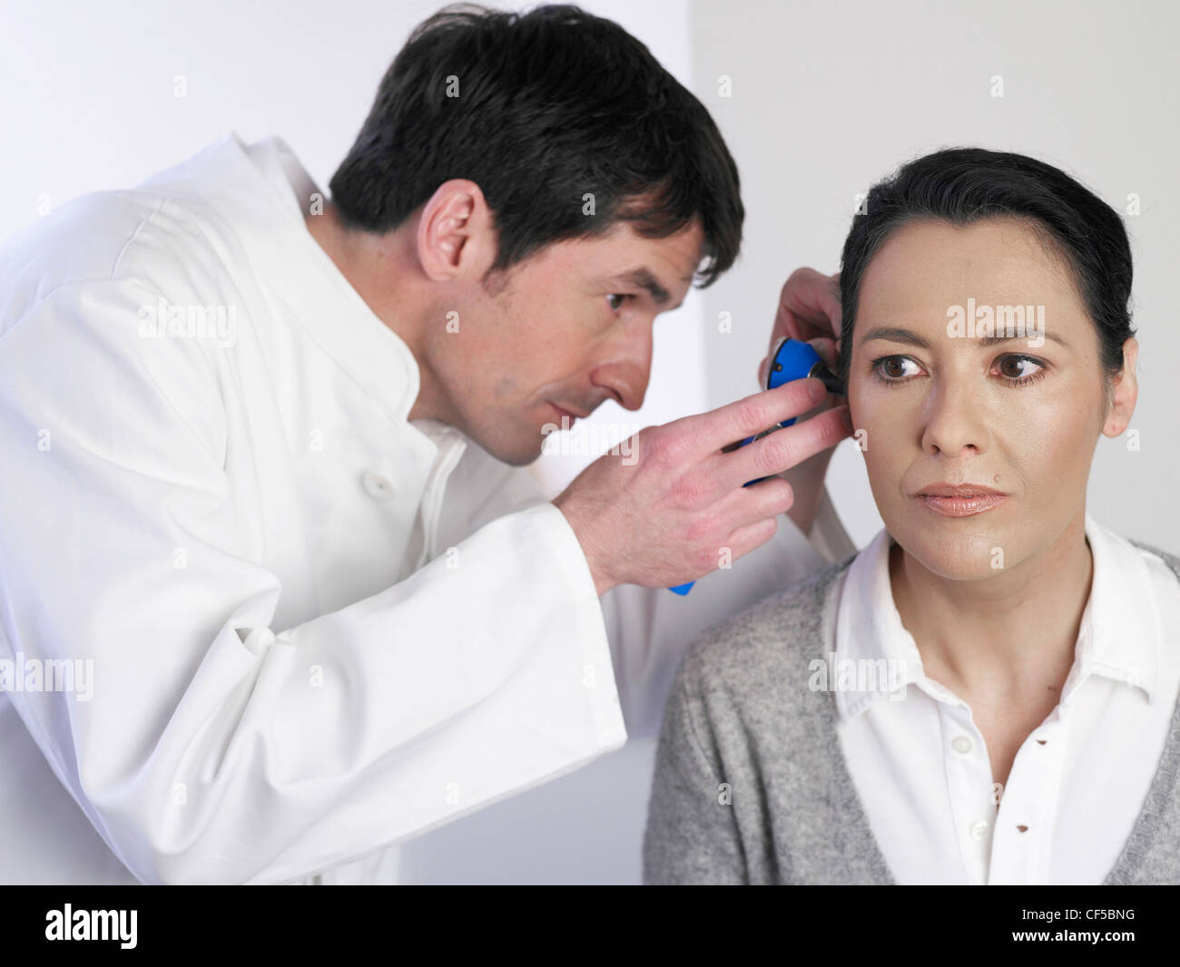 Germany, Hamburg, Doctor examining patient with medical equipment Stock