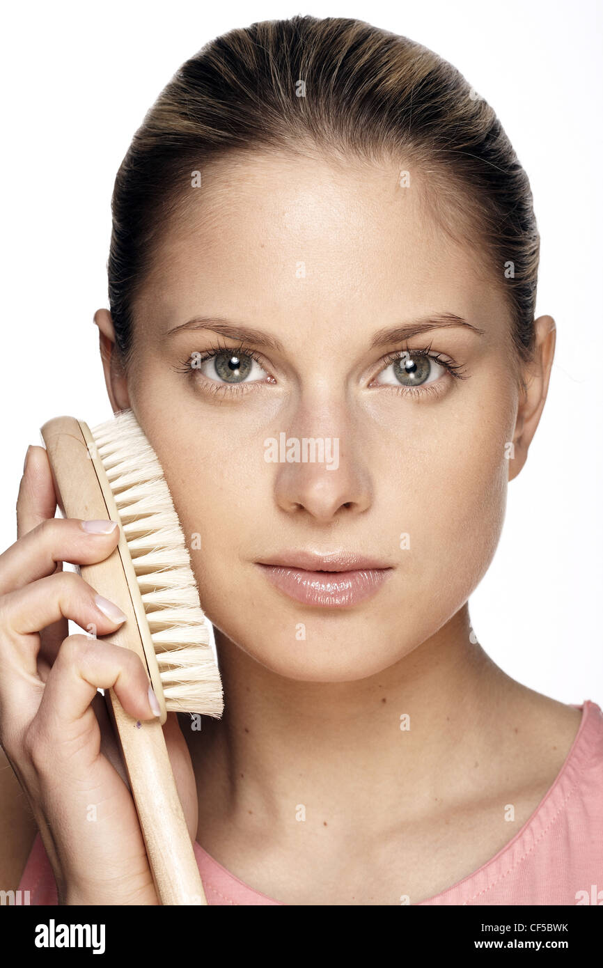 Female scrubbing face with body brush Stock Photo Alamy