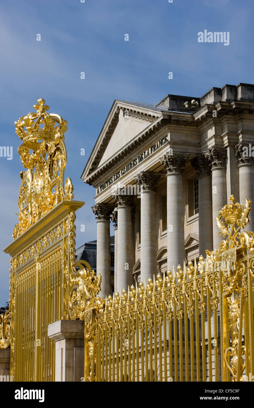 Gold gilded gates, colonnades and pediment at The Palace of Versailles, France Stock Photo