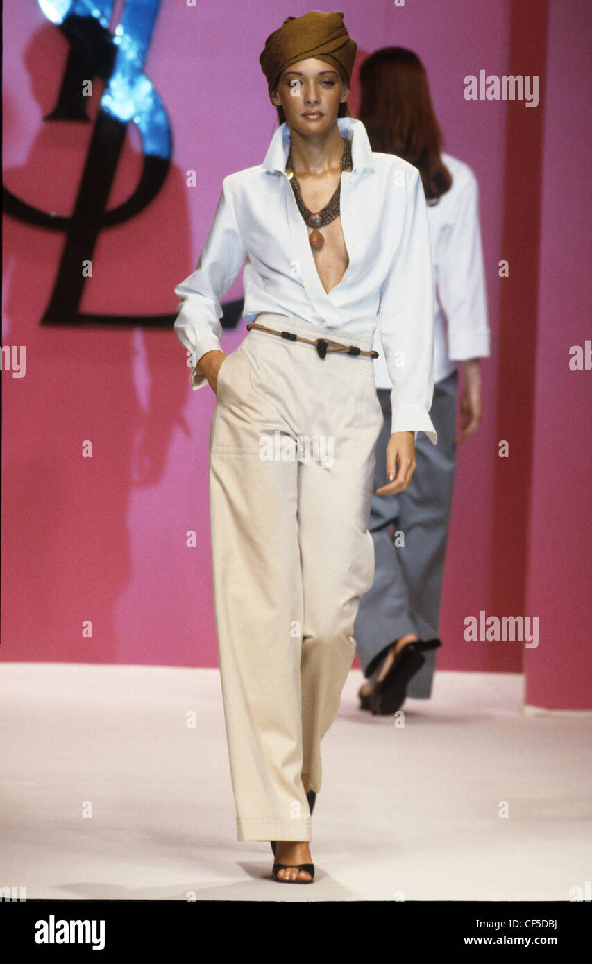 Yves Saint Laurent Spring Summer Female wearing white shirt, loose fit  beige trousers, and brown turban Stock Photo - Alamy