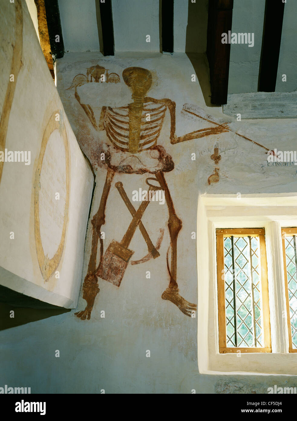 A figure of Death with pick, shovel, arrow and partly erased winged hourglass painted around 1748 at the west end of Llangar Old Stock Photo
