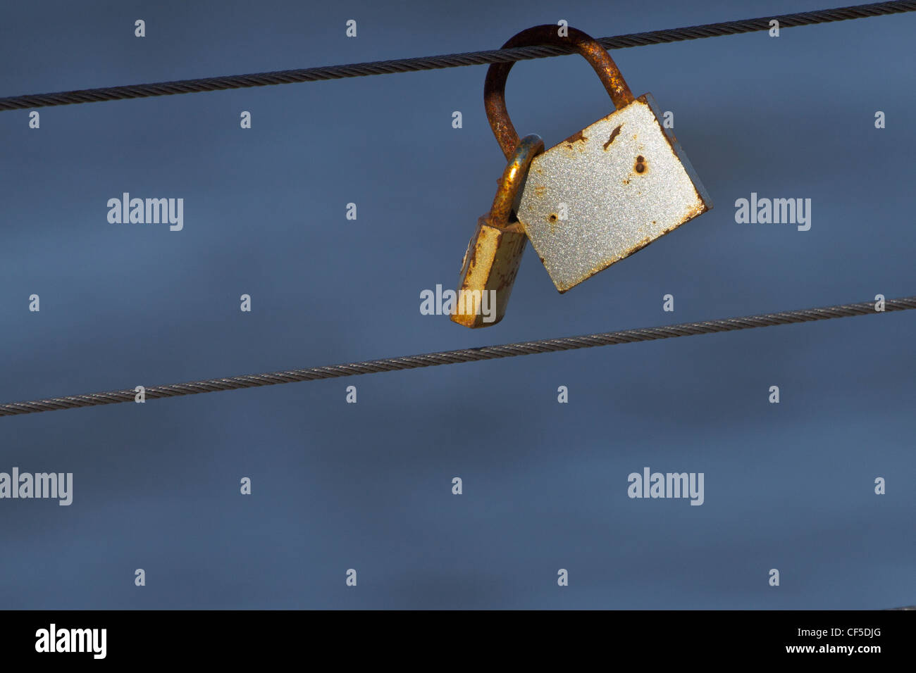 Rusty padlocks hanging on the cable in Rewal, Poland. Stock Photo