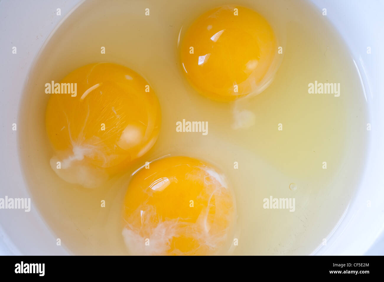 Uncooked eggs in a bowl Stock Photo