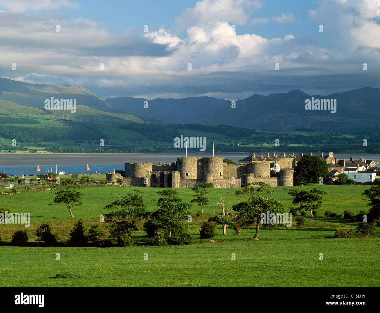 A general view of Edward I's Beaumaris Castle looking south to the Menai Strait and the mountains of Snowdonia. Stock Photo