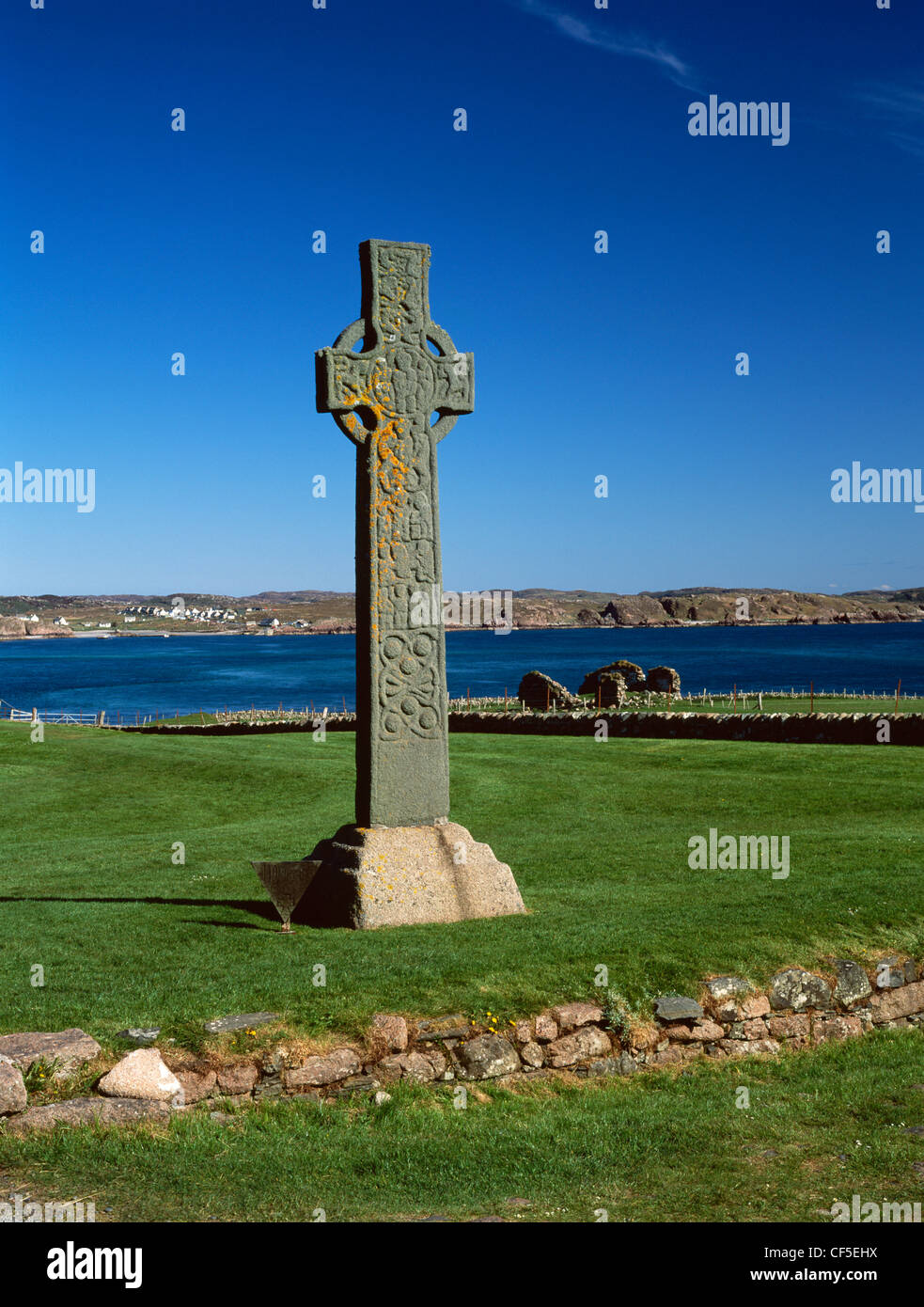 The west face of St Martin's mid-8th century, Celtic High Cross and the ruins of St Mary's Chapel. Beyond are the Sound of Iona Stock Photo