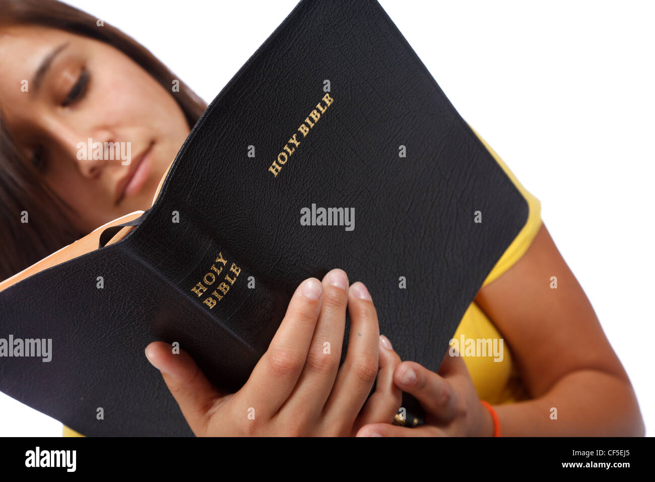 Young girl reading Holy Bible, focus is on the black leather bible