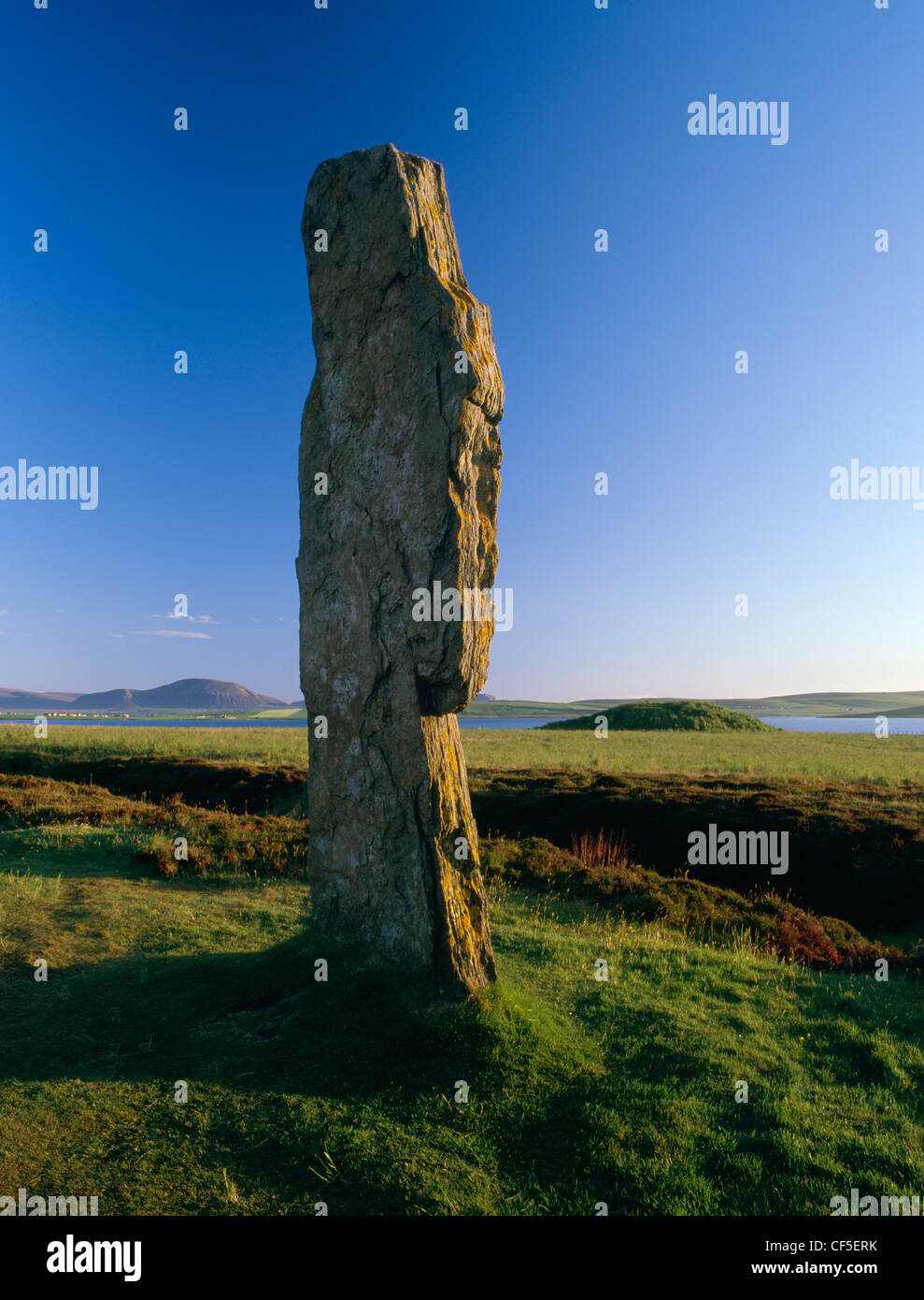 Looking from the tall western slab of the Ring of Brodgar stone circle, across the Loch of Stenness to Ward Hill on the island o Stock Photo
