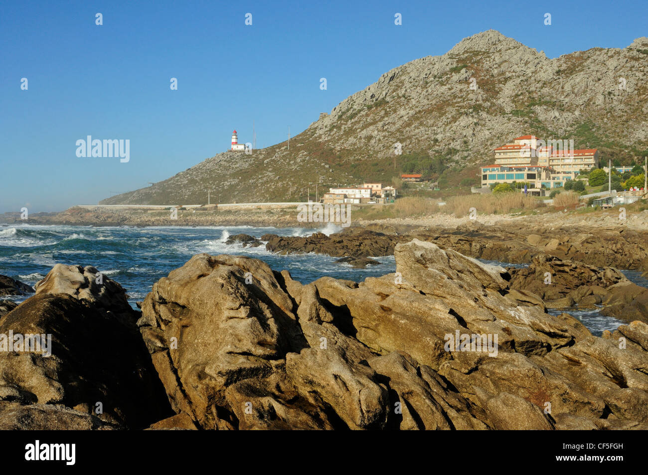 Coastal rockery in As Mariñas and Cape Silleiro lighthouse. Galicia, Spain Stock Photo