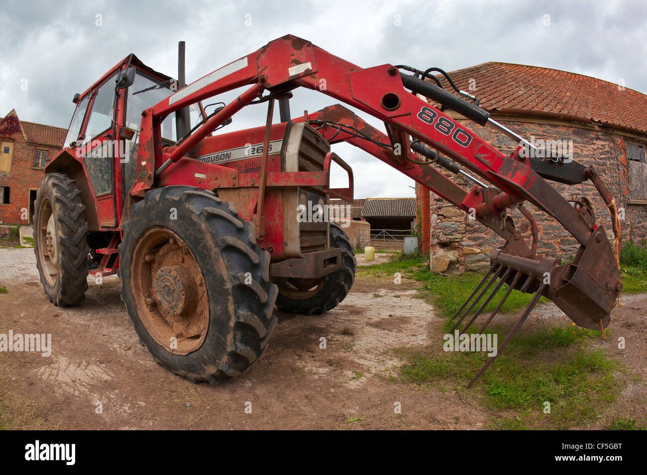 A tractor parked in a farmyard. Stock Photo
