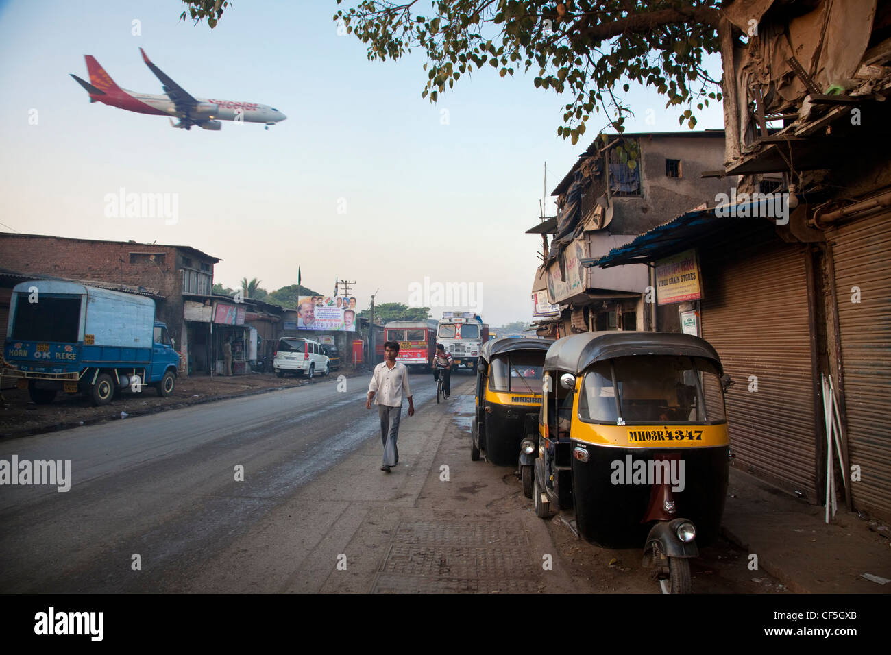 Plane landing at Mumbai International Airport next to slums Stock Photo