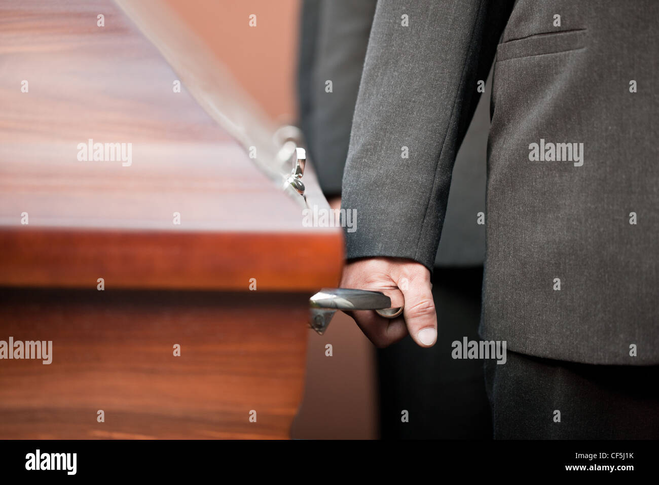 Religion, death and dolor - coffin bearer carrying casket at funeral to cemetery Stock Photo