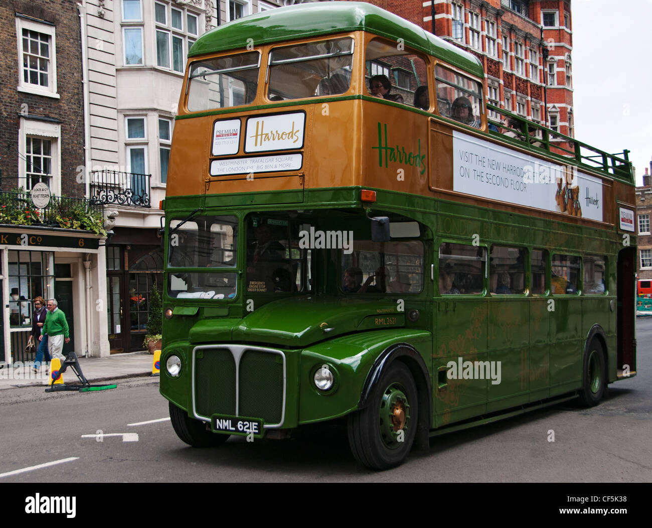 An open-topped vintage Routemaster tour bus in Harrods livery travelling along St James's Street. Stock Photo