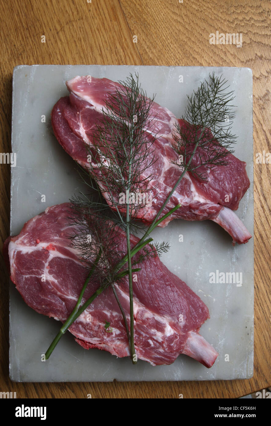 Two neck chops on cutting board with sprigs of dill on top Stock Photo ...