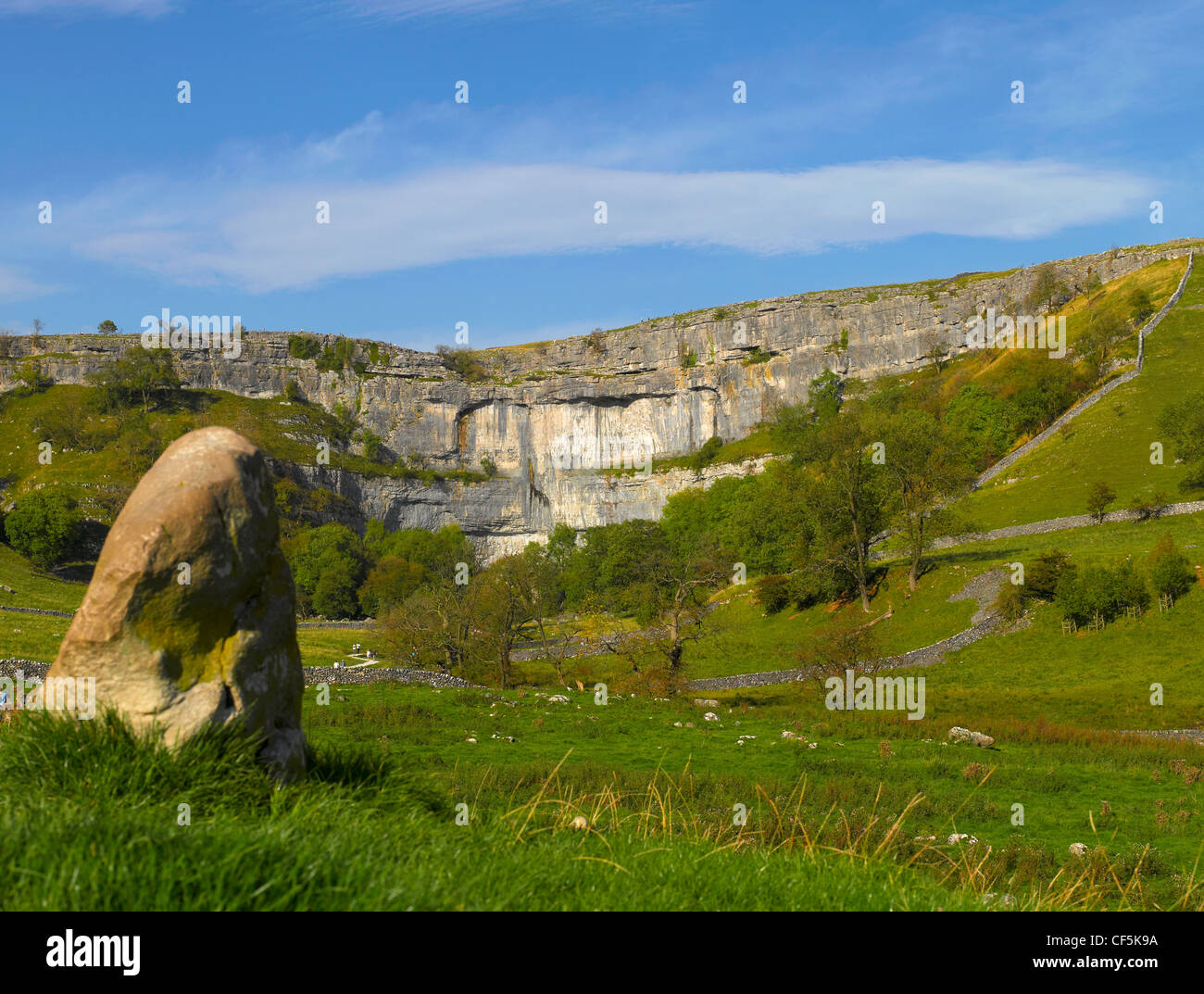 People exploring Malham Cove, an 80 metre high limestone crag formed after the last ice age. Stock Photo