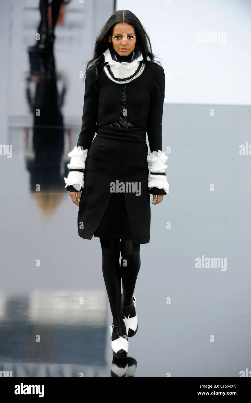 Chanel Paris Ready to Wear Autumn Winter Black skirt suit white frilled  neck and white frilled sleeves, black tights, black Stock Photo - Alamy