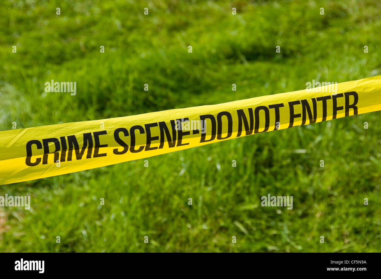 Police tape with the words CRIME SCENE-DO NOT ENTER. Stock Photo