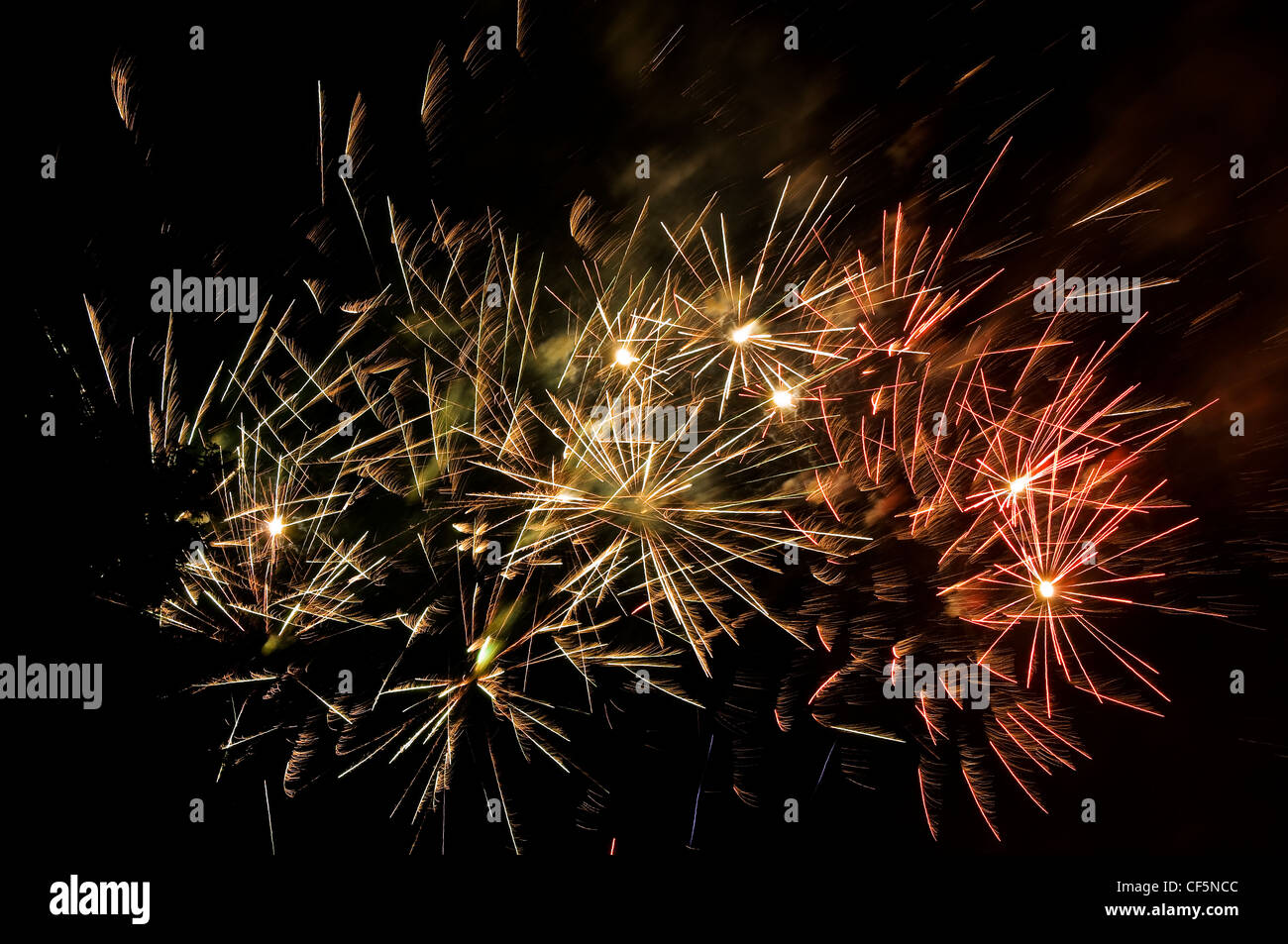 Spectacular trails of light from fireworks exploding in the evening sky on bonfire night. Stock Photo