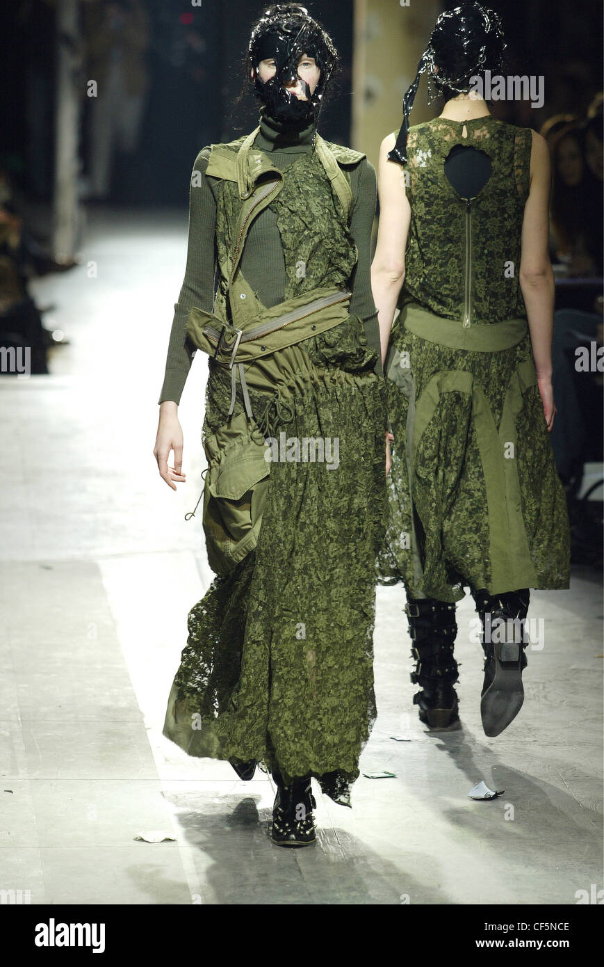 Junya Watanabe Model wearing mask of black tape, hair and chains green  poloneck under deconstructed khaki dress drawstring Stock Photo - Alamy