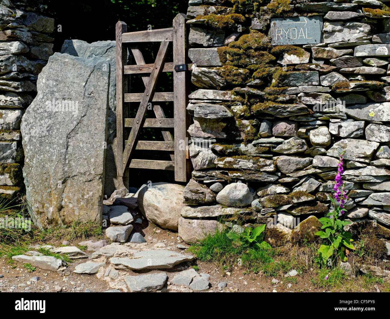 Sign showing the direction to Rydal beside a gate in a drystone wall. Stock Photo