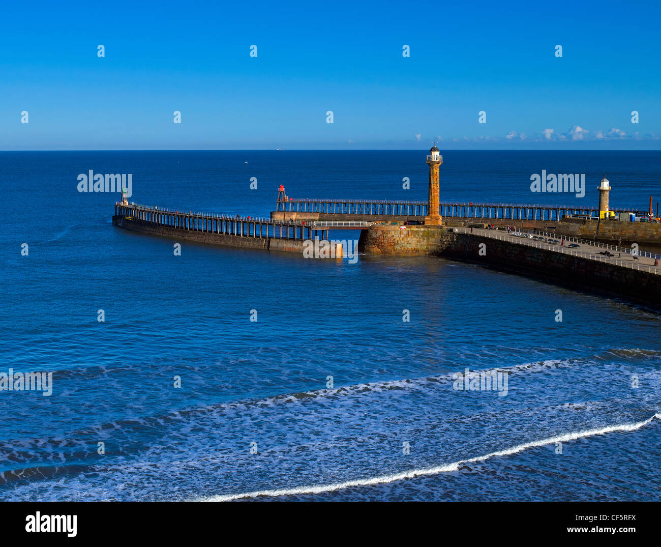 Waves rolling into land off the North sea past the West Pier and East Pier at the entrance to Whitby Harbour. Stock Photo