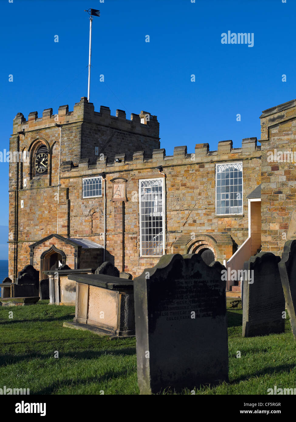 The fortress-like exterior of St. Mary's Church and churchyard at the top of 199 stone steps leading up East Cliff from the town Stock Photo