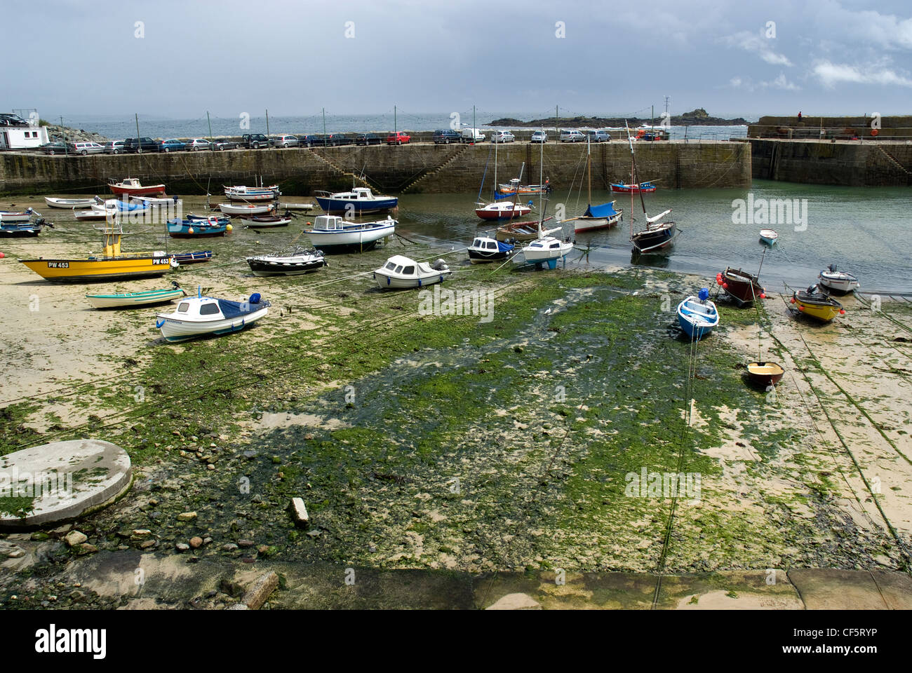 Boats in Mousehole Harbour at low tide. Stock Photo