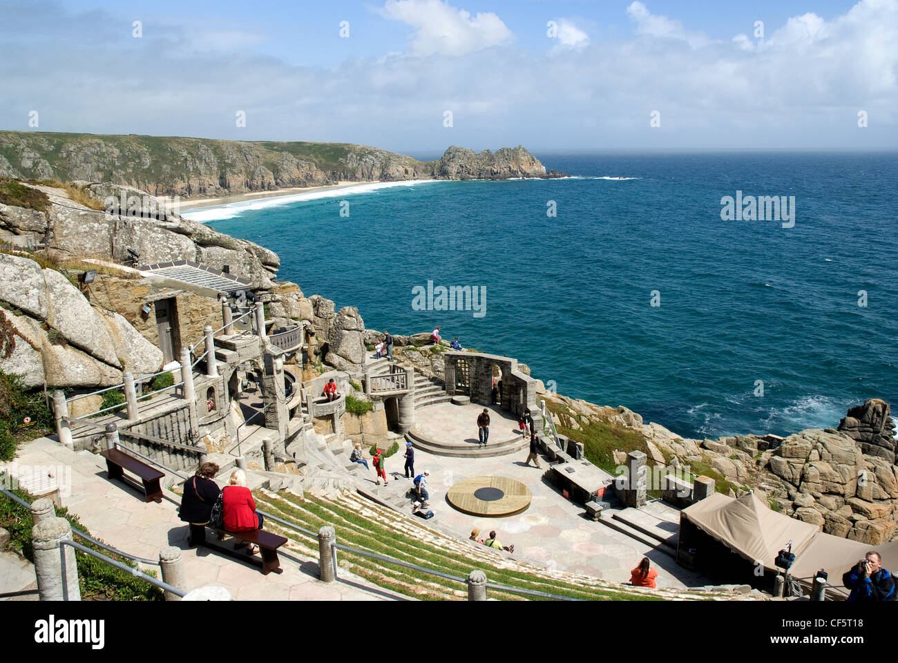 A view down over the steep seating and stage at the Minack Theatre towards Porthcurno Bay and Logan Rock in the background. Stock Photo