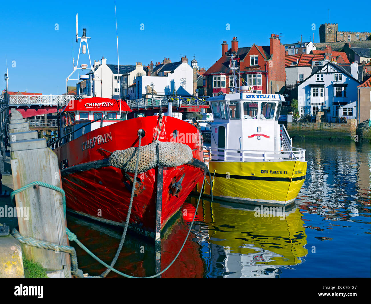 St Mary's Church on East Cliff overlooking fishing boats moored in the harbour. Stock Photo