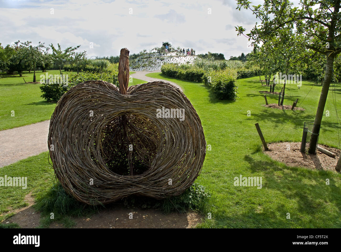 A garden sculpture of half an apple by a path leading to the fruit mount in the fruit field at RHS Wisley. The fruit field conta Stock Photo