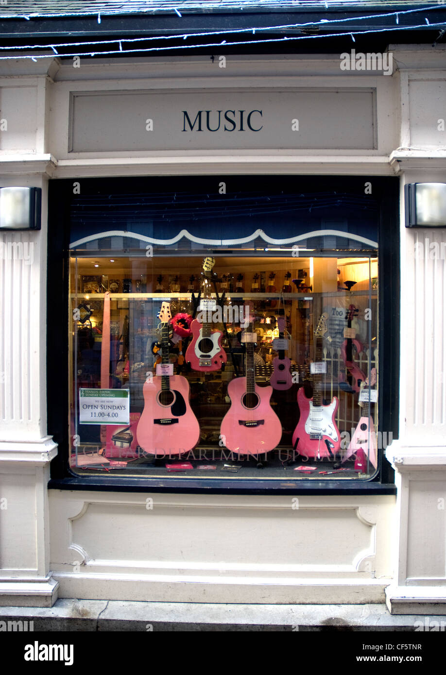 A window display of a music shop with an array of pink coloured guitars in Kingston upon Thames. Stock Photo