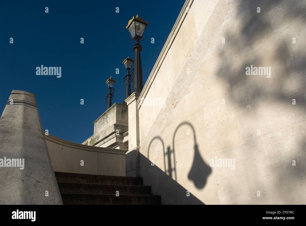 The shadow from an old street lamp on the stonework by steps leading up to Kingston Bridge. Stock Photo