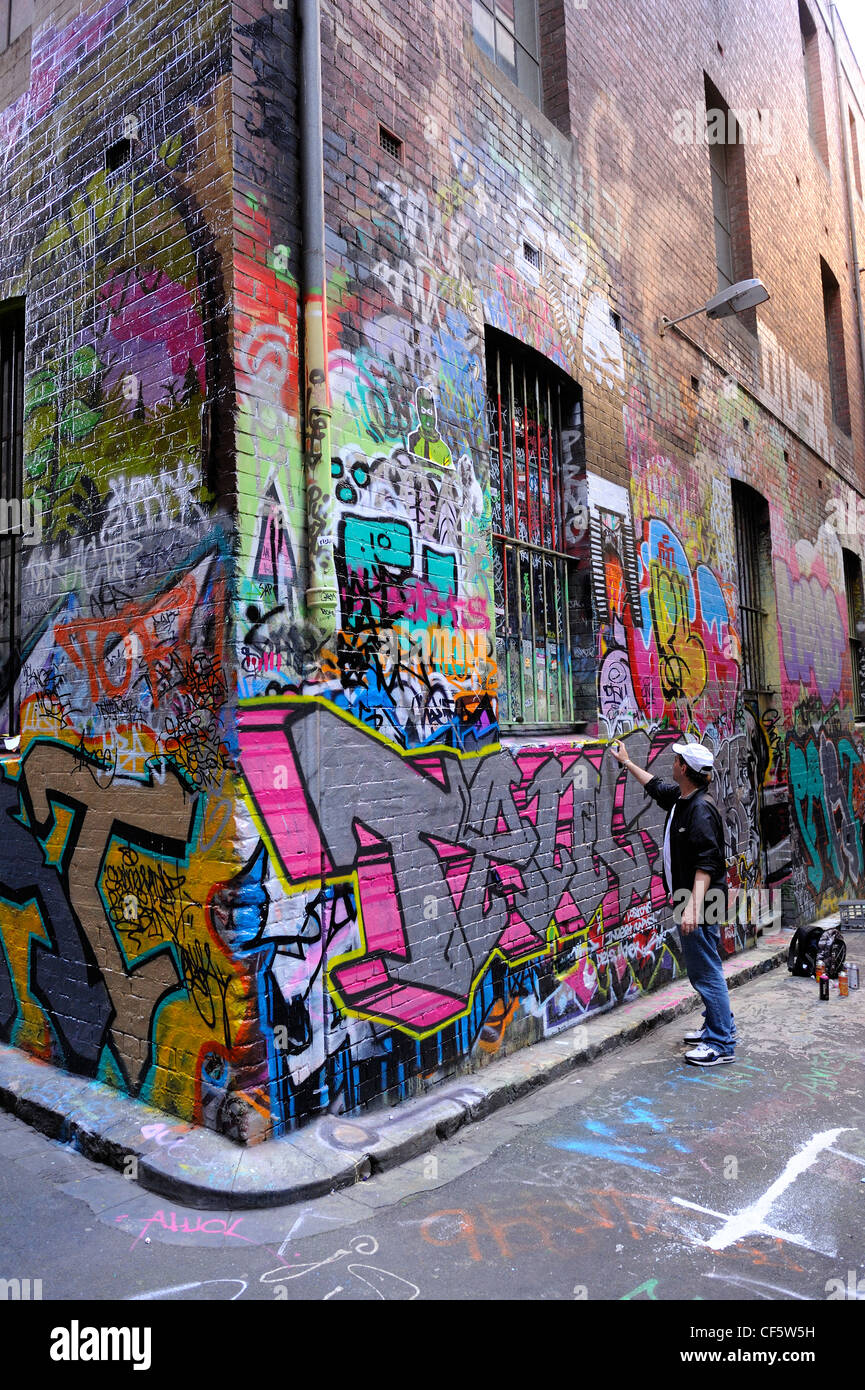 Graffiti artist spraying on wall, Hosier Lane, Melbourne, Victoria