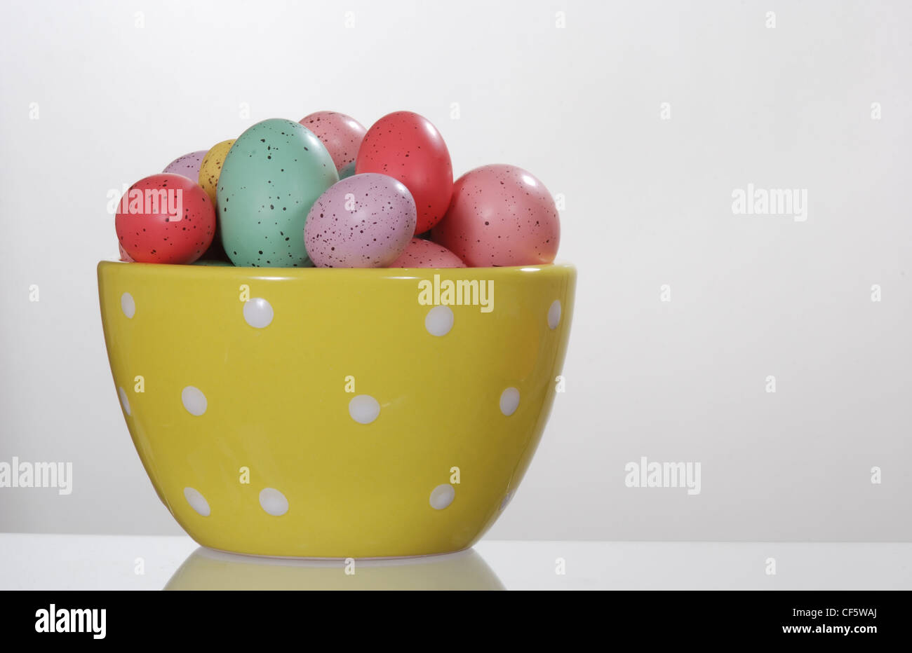 Easter eggs in a polka dot bowl. Isolated on white. Stock Photo