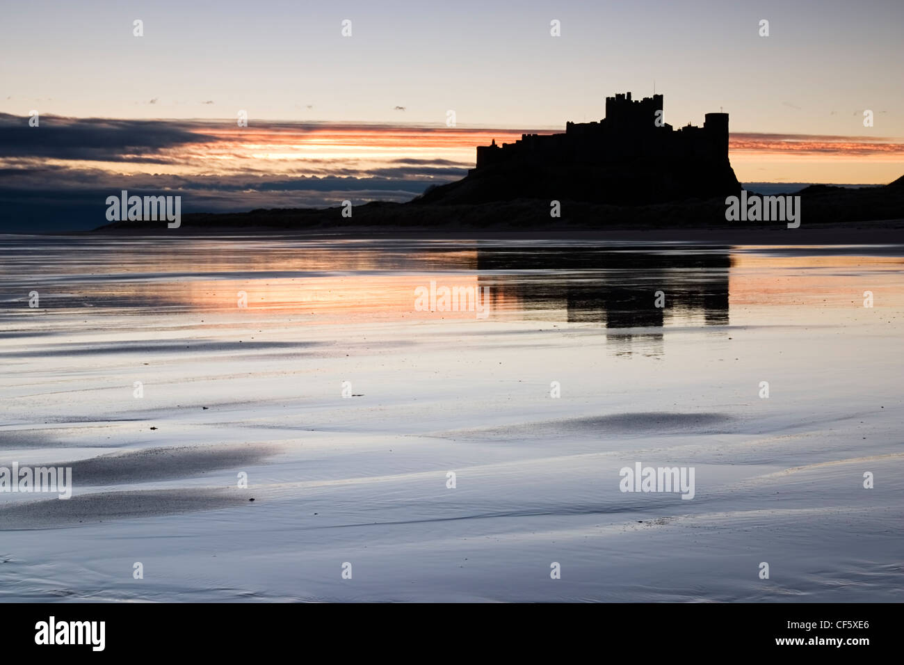 The outline of Bamburgh Castle against the sunrise. In the Wars of the Roses, Bamburgh was held by the Lancastrians and in 1464 Stock Photo