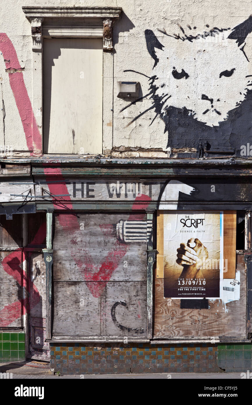Run down and boarded up derelict pub covered with graffiti. Stock Photo