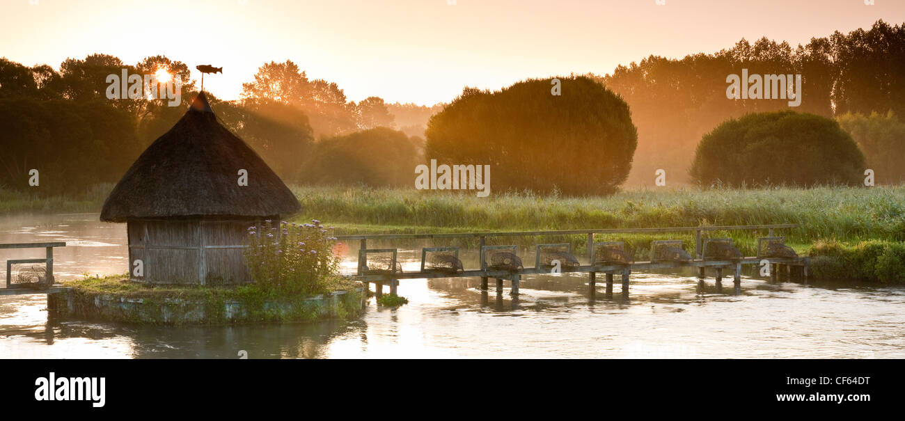 Panoramic view of thatched fishing hut and Eel traps on the River Test at Longstock Stock Photo