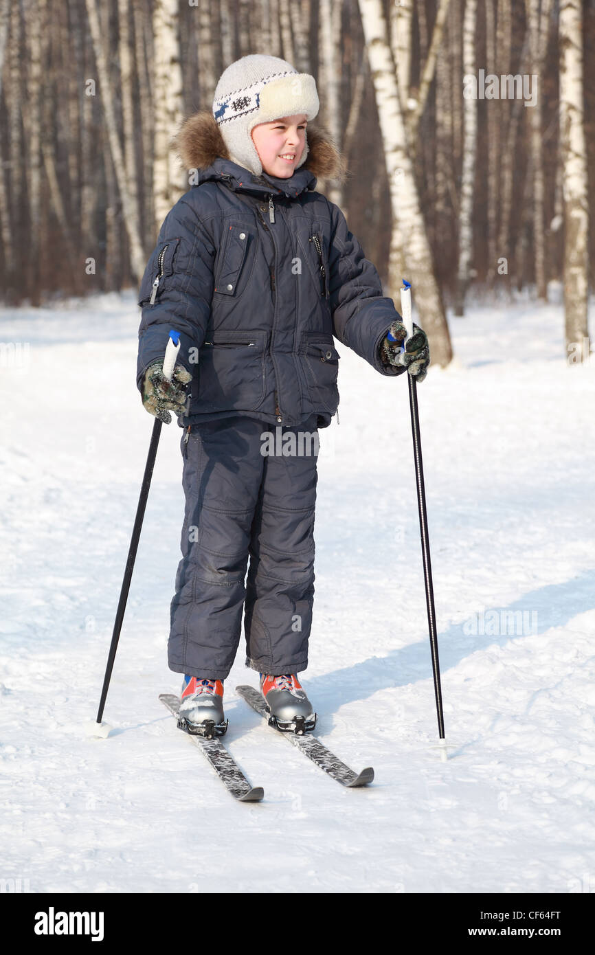 Young boy stands on crosscountry skis and looking to side inside