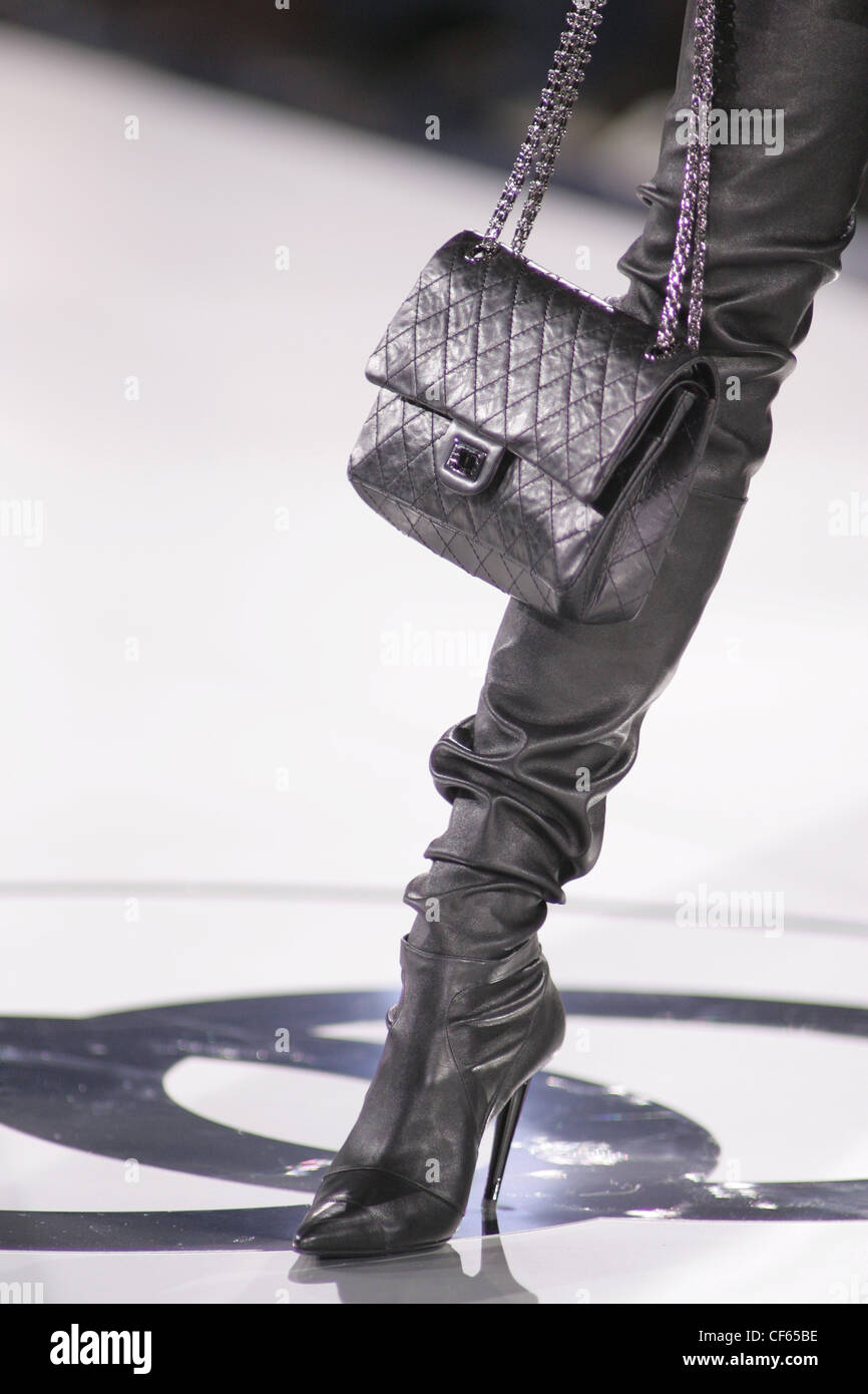 Chanel Paris Ready to Wear Autumn Winter Leather trousers tucked into  leather knee high boots; Chanel handbag with chain strap Stock Photo - Alamy