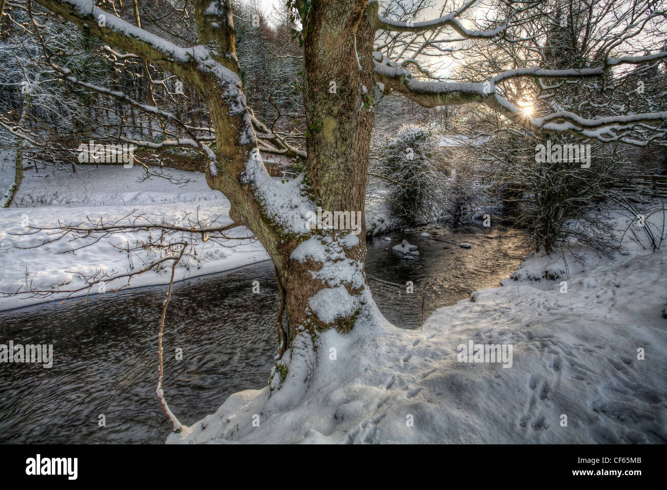 Sunset over a tributary stream of the River Wear, with both banks covered in snow. Stock Photo