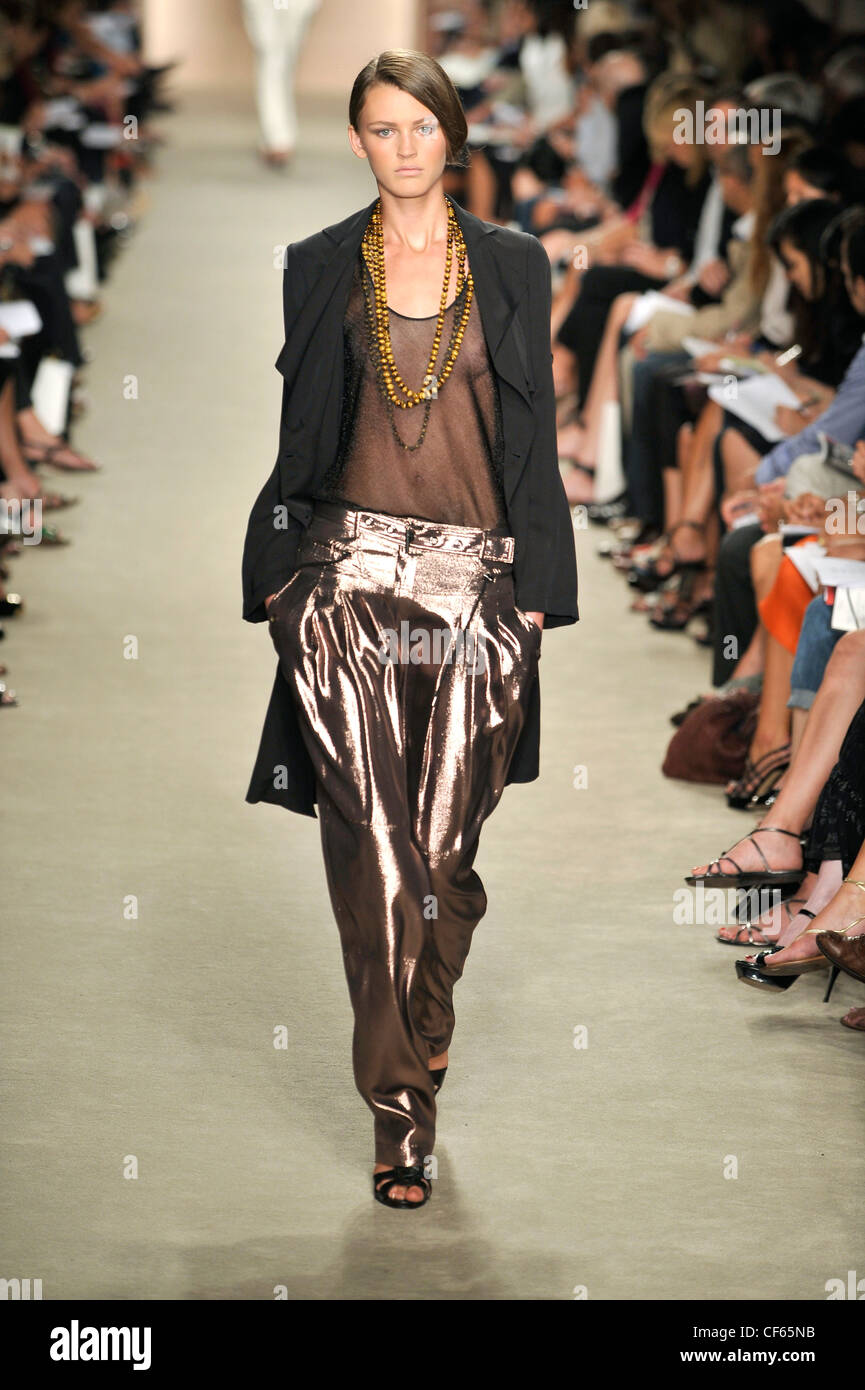 Derek Lam New York Ready to Wear Spring Summer Model wearing a sheer black  top, a charcoal double breasted rain coat, baggy Stock Photo - Alamy