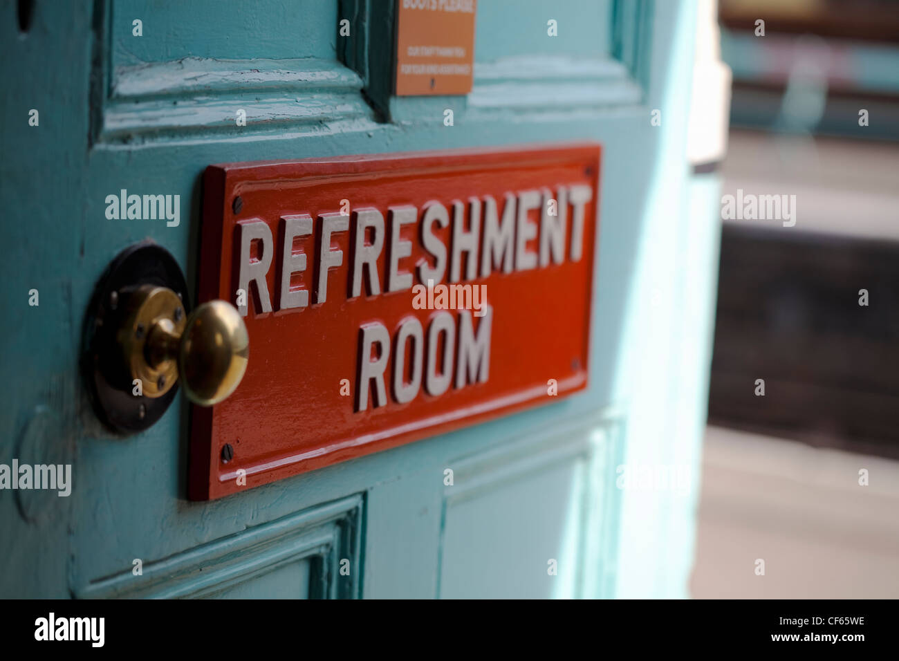 A sign reading 'Refreshment Room' on a door leading off a train station platform. Stock Photo