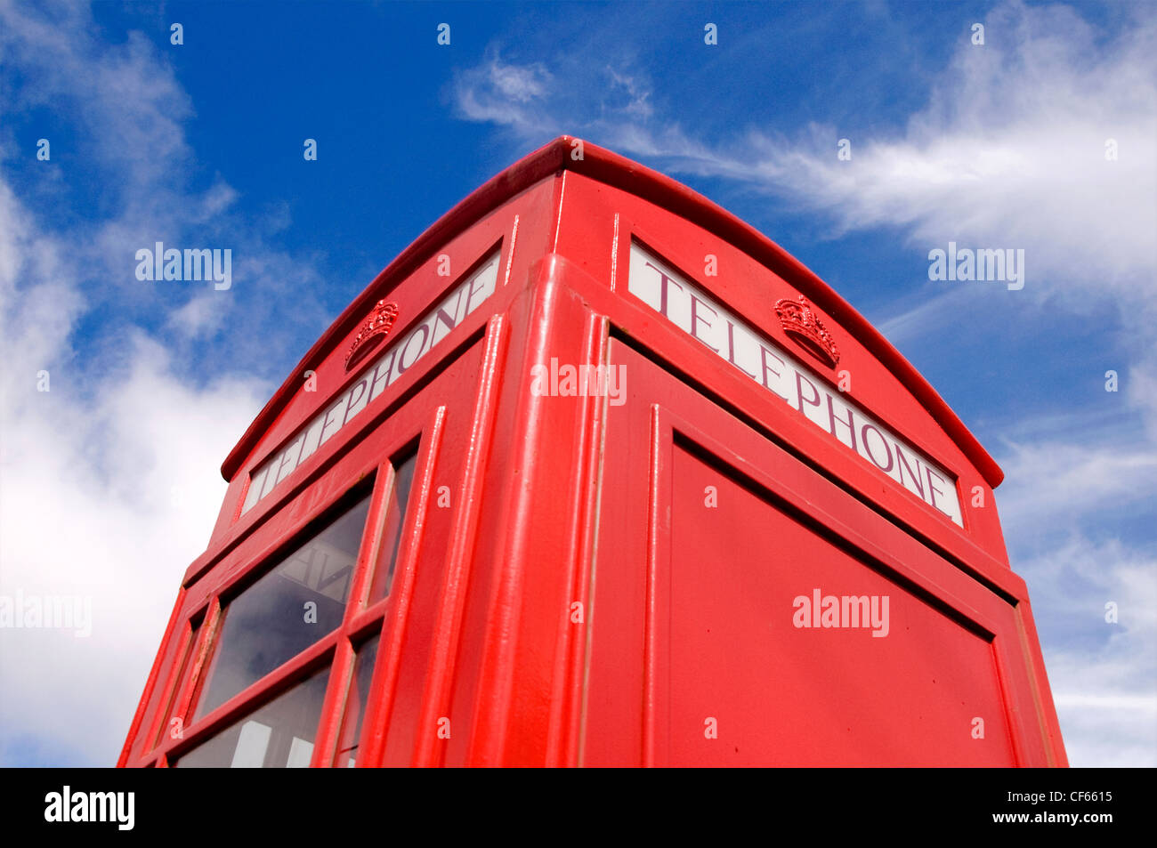 An iconic British telephone box contrasted against a blue sky. Stock Photo