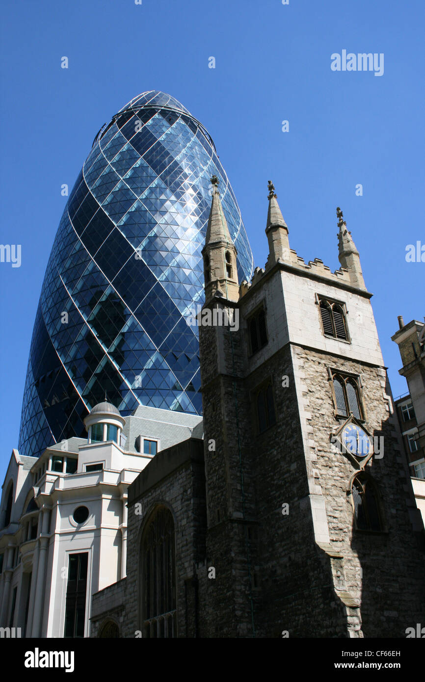 The Gherkin behind St Andrew Undershaft Church in London. Stock Photo