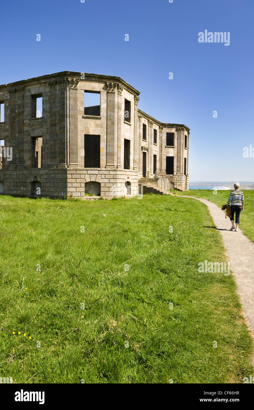 A woman walking along a path leading to the remains of Downhill House. Stock Photo