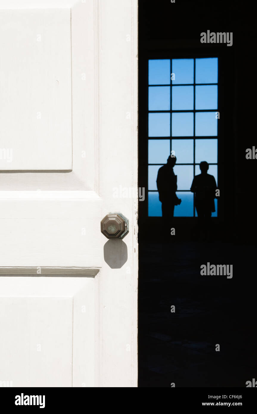 Looking through a doorway to two figures silhouetted against a window inside Mussenden Temple. Stock Photo