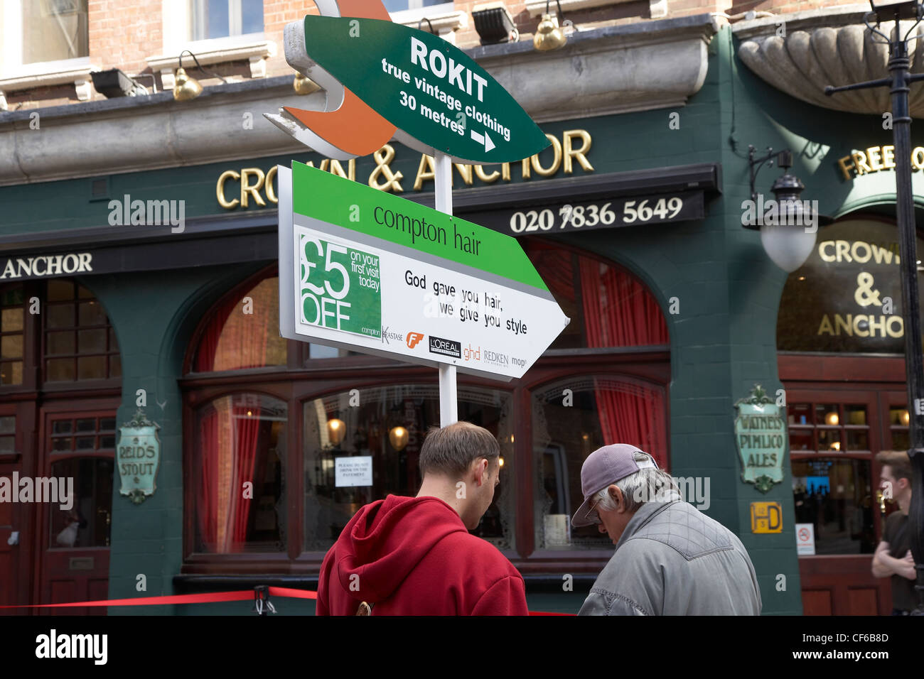 Young man giving directions in Covent Garden outside the Crown and Anchor pub. Stock Photo