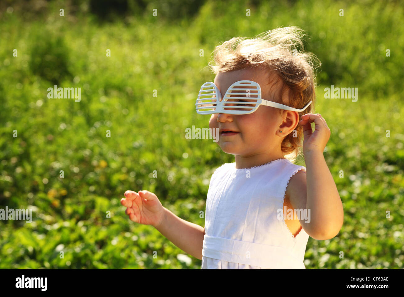 The little girl in the blinds-glasses worn upside down Stock Photo