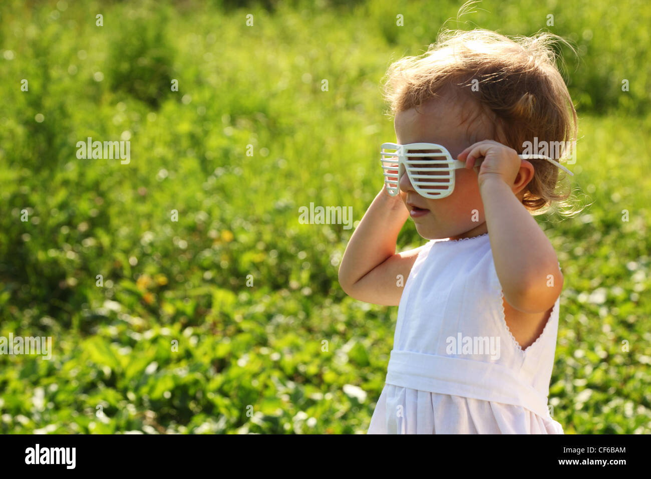 The little girl wearing the blinds-glasses Stock Photo